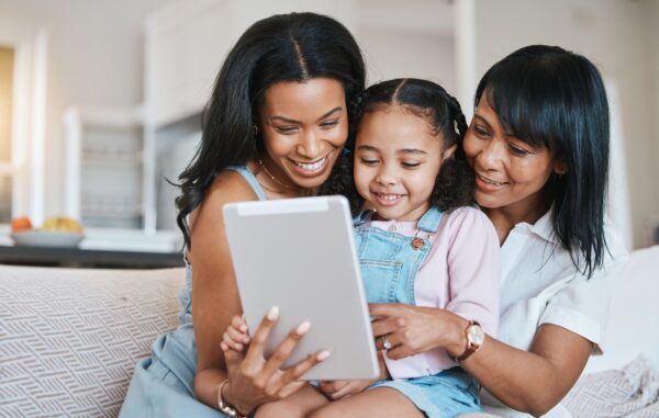 Family, tablet and child on a children education app with mother and grandparent at home. Happiness