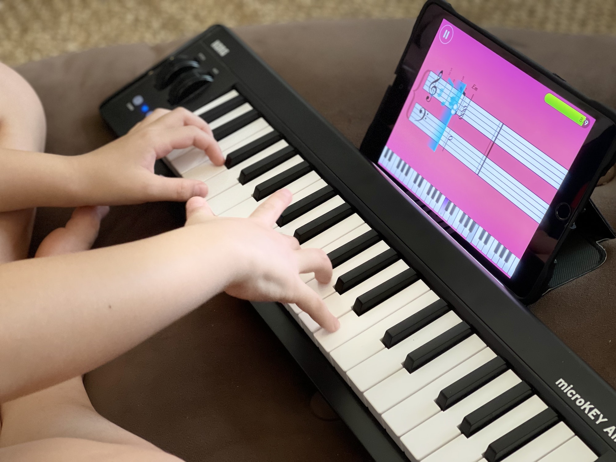Kid playing the piano using an app on iPad